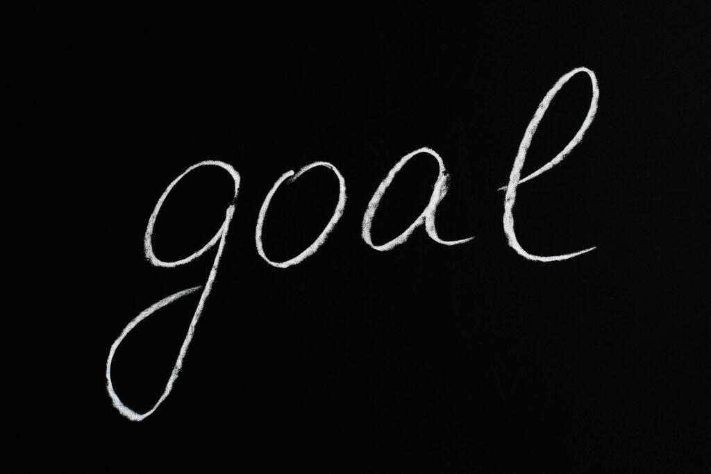 pexels photo 5598296 5598296 Elegant handwritten 'goal' on a black chalkboard background conveying ambition and purpose.